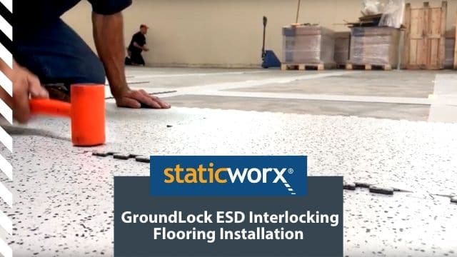 Background image is a cropped photo of a contractor hitting a GroundLock Extreme ESD interlocking tile into place with an orange mallet. In the foreground at the bottom are two boxes. The top is a bright blue with the StaticWorx logo. The second is a dark blue-gray and includes the text in white: “GroundLock ESD Interlocking Flooring Installation”