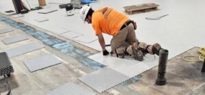 In progress installation of GroundLock Extreme interlocking ESD tiles with minimal floor prep directly over a subfloor with cracks, swales and moisture problems.
