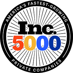 The Inc. 5000 logo. In the center is "Inc." in black with the numbers underneath: 5 (in red), 0 (in orange-yellow), 0 in bright blue, 0 in navy blue. Lines extend right round the image from the center to a thick black rim. In the rim are the words "America's Fastest-Growing" (at the top) and "Private Companies" (at the bottom)