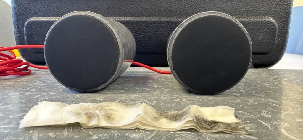 Photo of two probes on their side with bases visible. A cloth can be seen in front of them, showing dirt that has been removed.