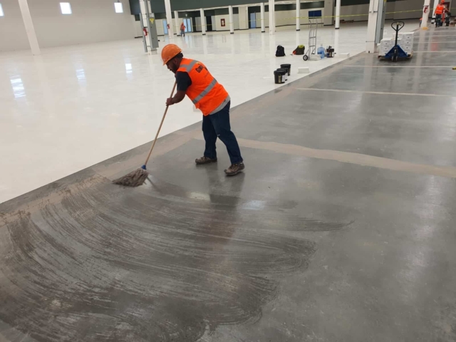 A contractor preparing concrete for an installation of ESD flooring.