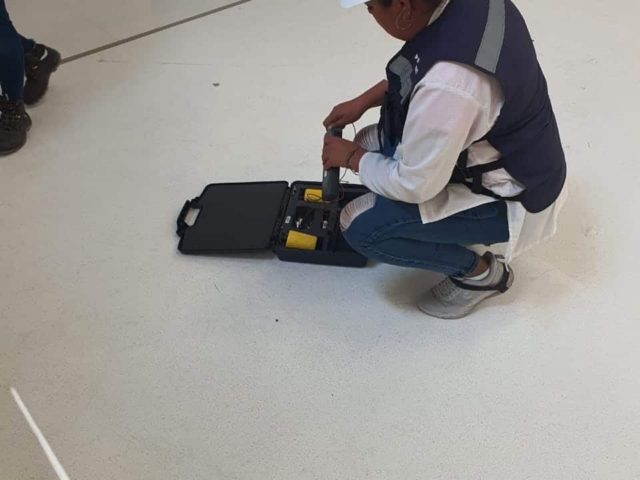 A contractor testing the electrical resistance of installed AmeriWorx ESD vinyl tile flooring.
