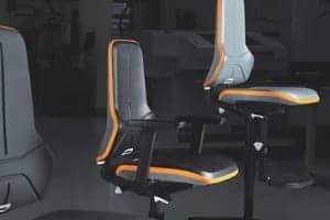 A photograph of two black StaticWorx Bolt ESD chairs with orange trim.